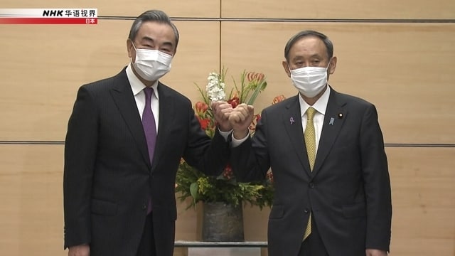 25日，日本首相菅义伟在东京会见中国国务委员兼外长王毅